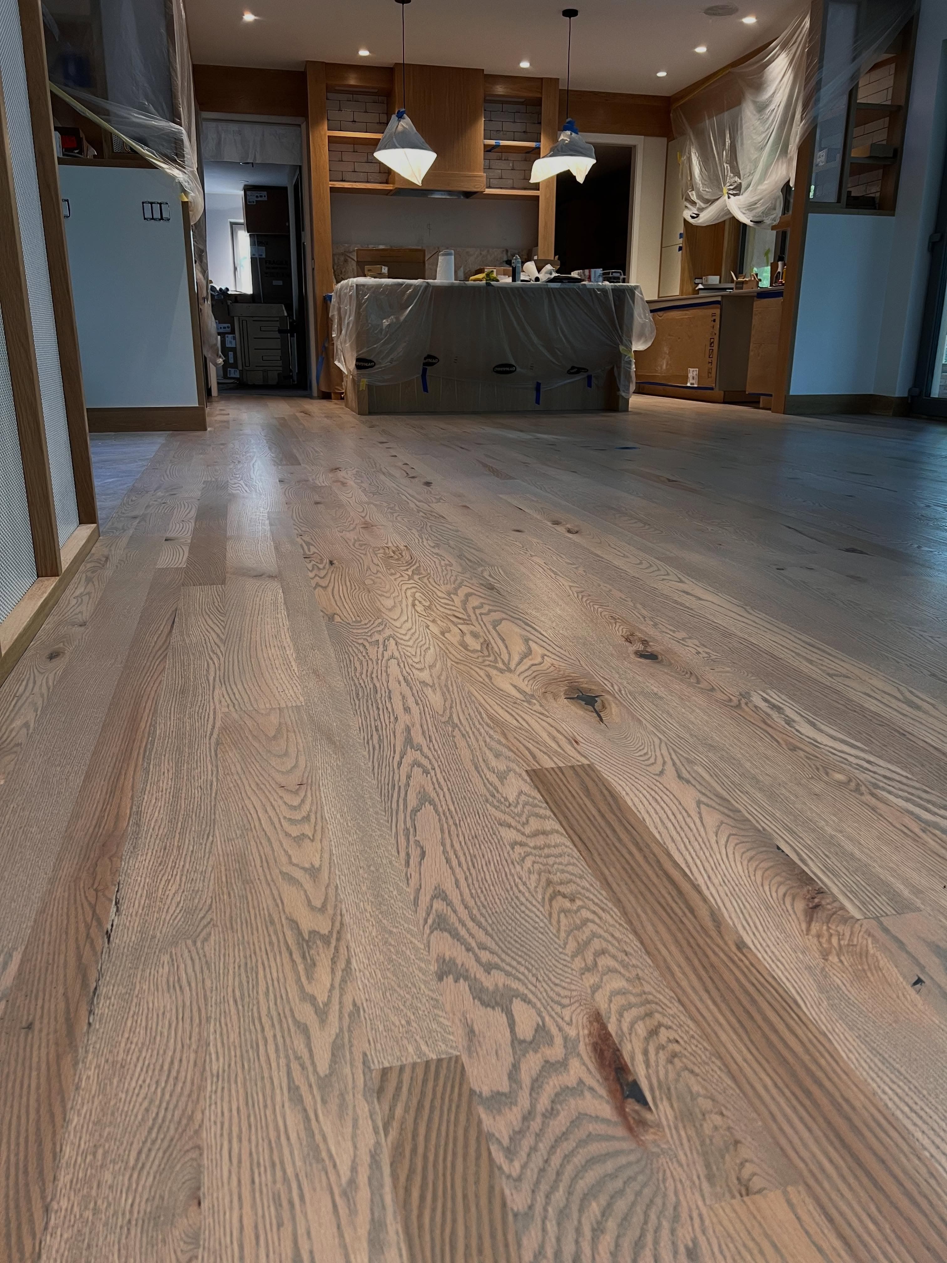 Commercial interior with light wood plank flooring, exposed ceiling, pendant lighting