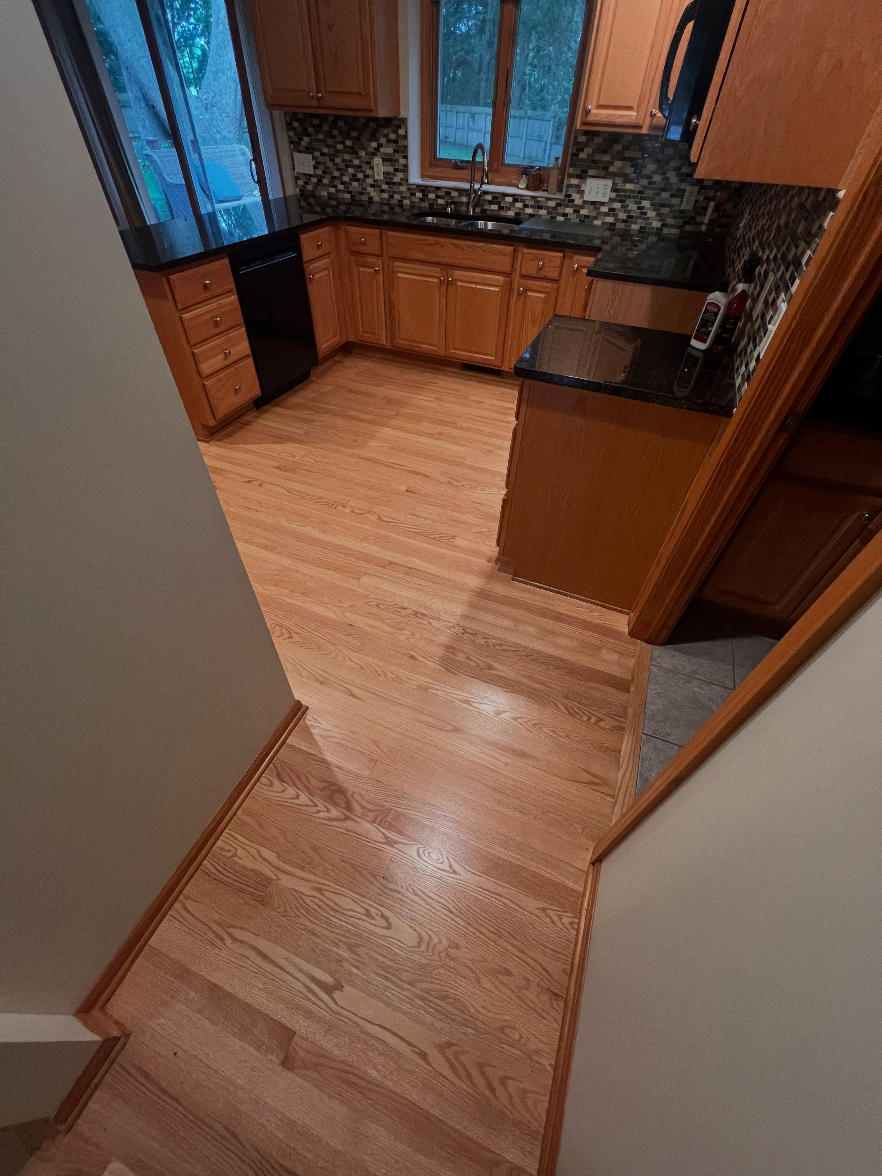 Kitchen transition showing wood flooring into entryway from elevated perspective