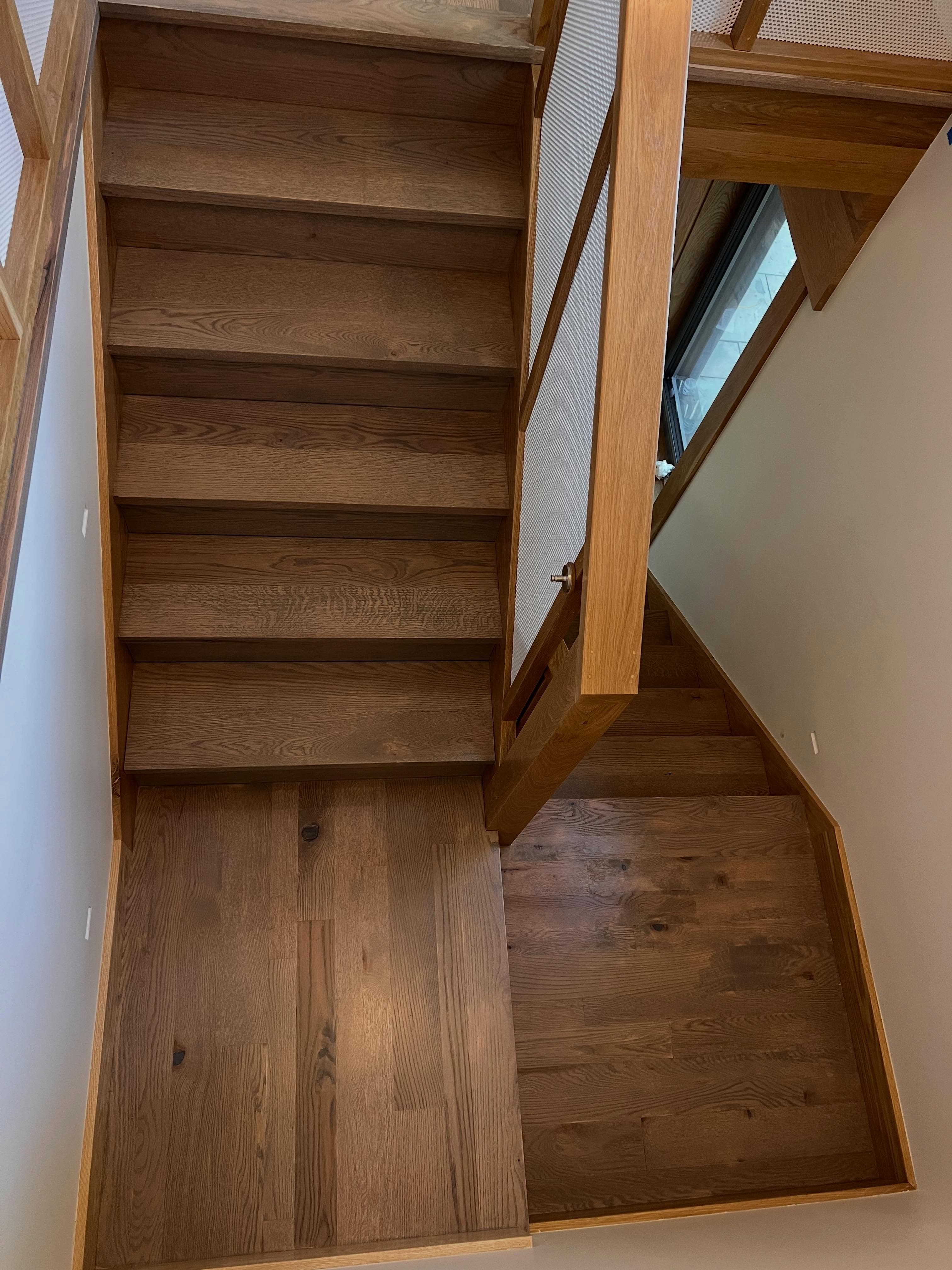 Staircase landing with wood-look vinyl flooring, open staircase design