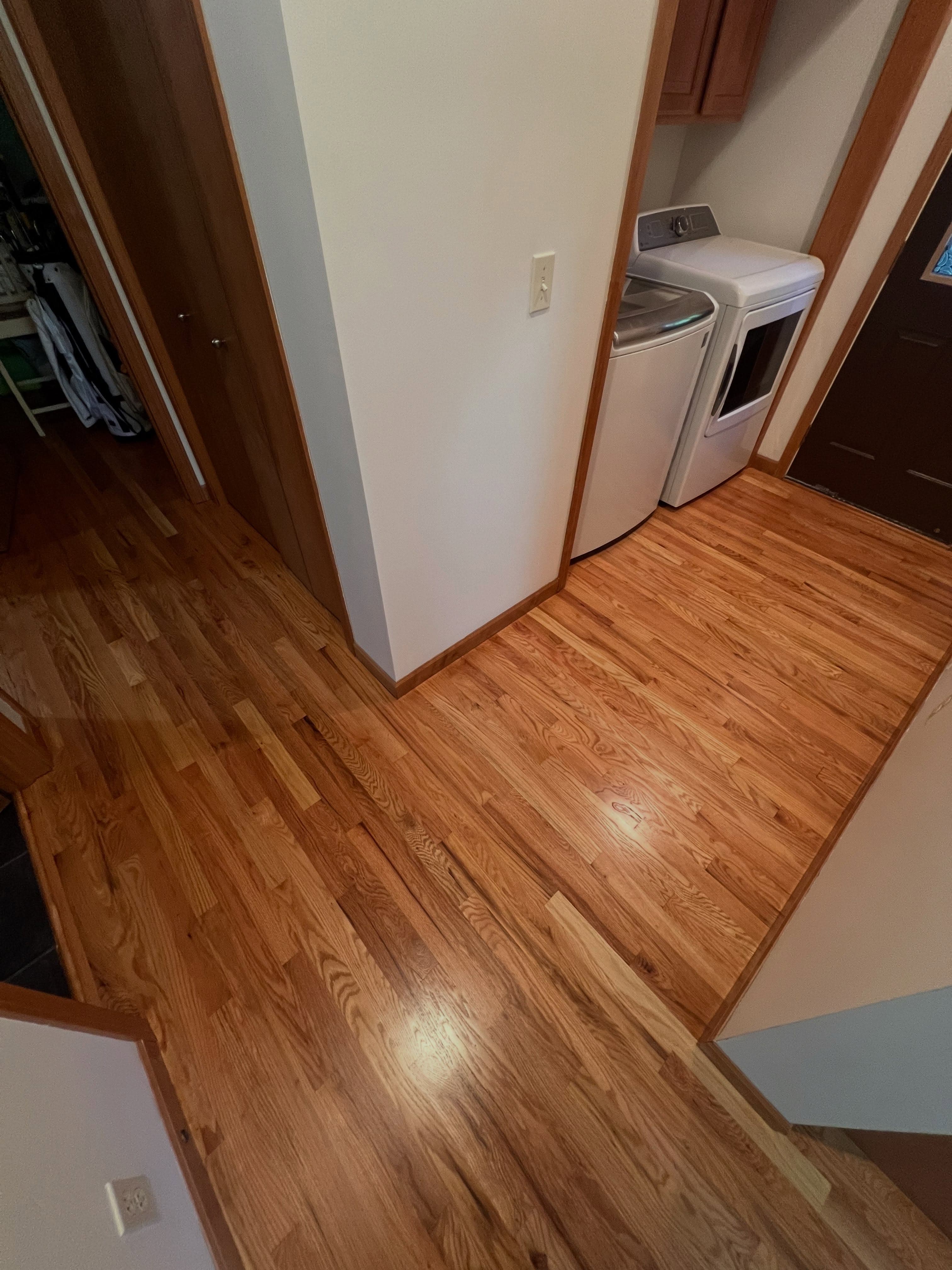 Laundry room with wood-look vinyl flooring, room transition visible