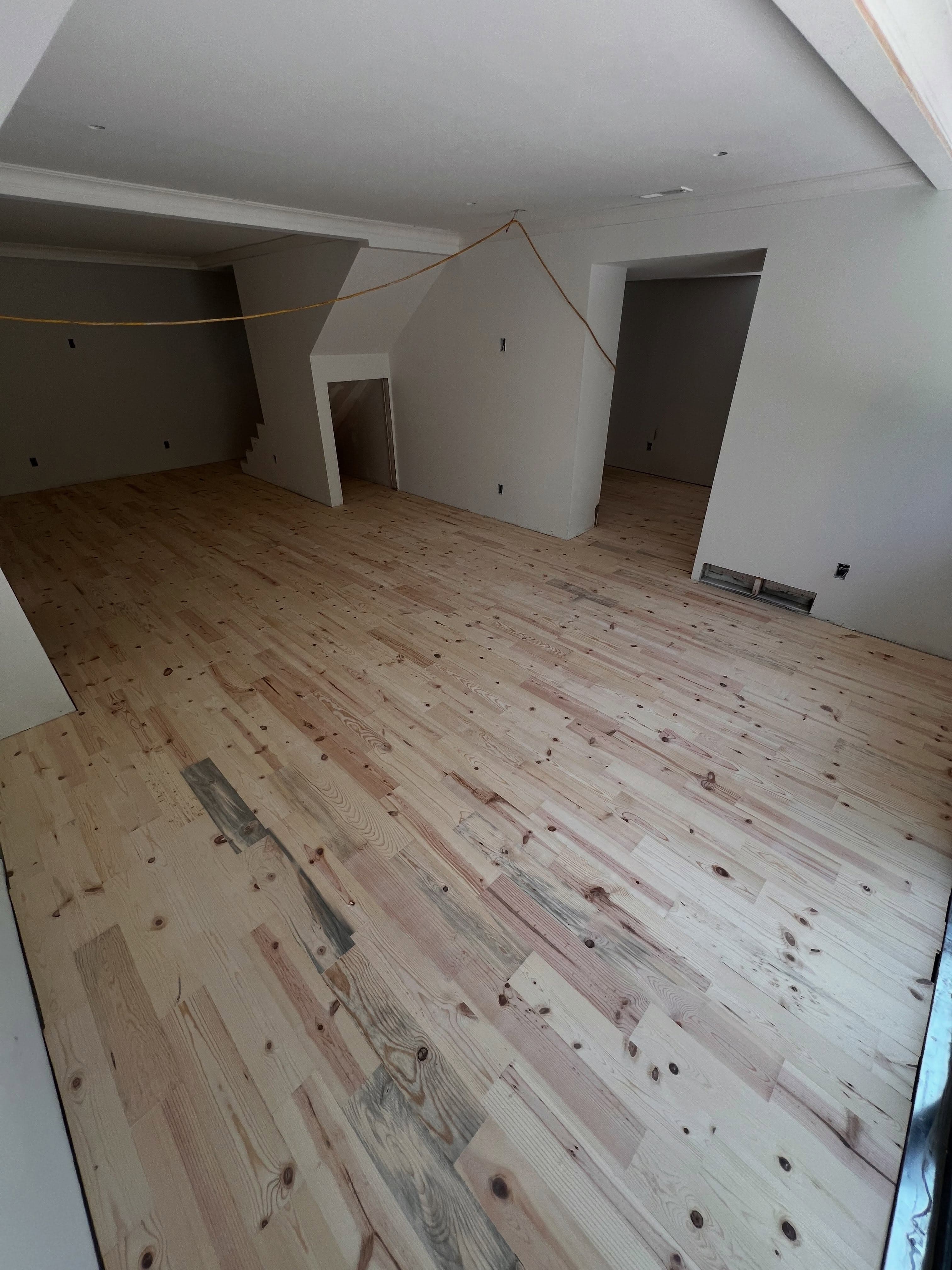 Empty room with pine subfloor showing installation marks, new construction