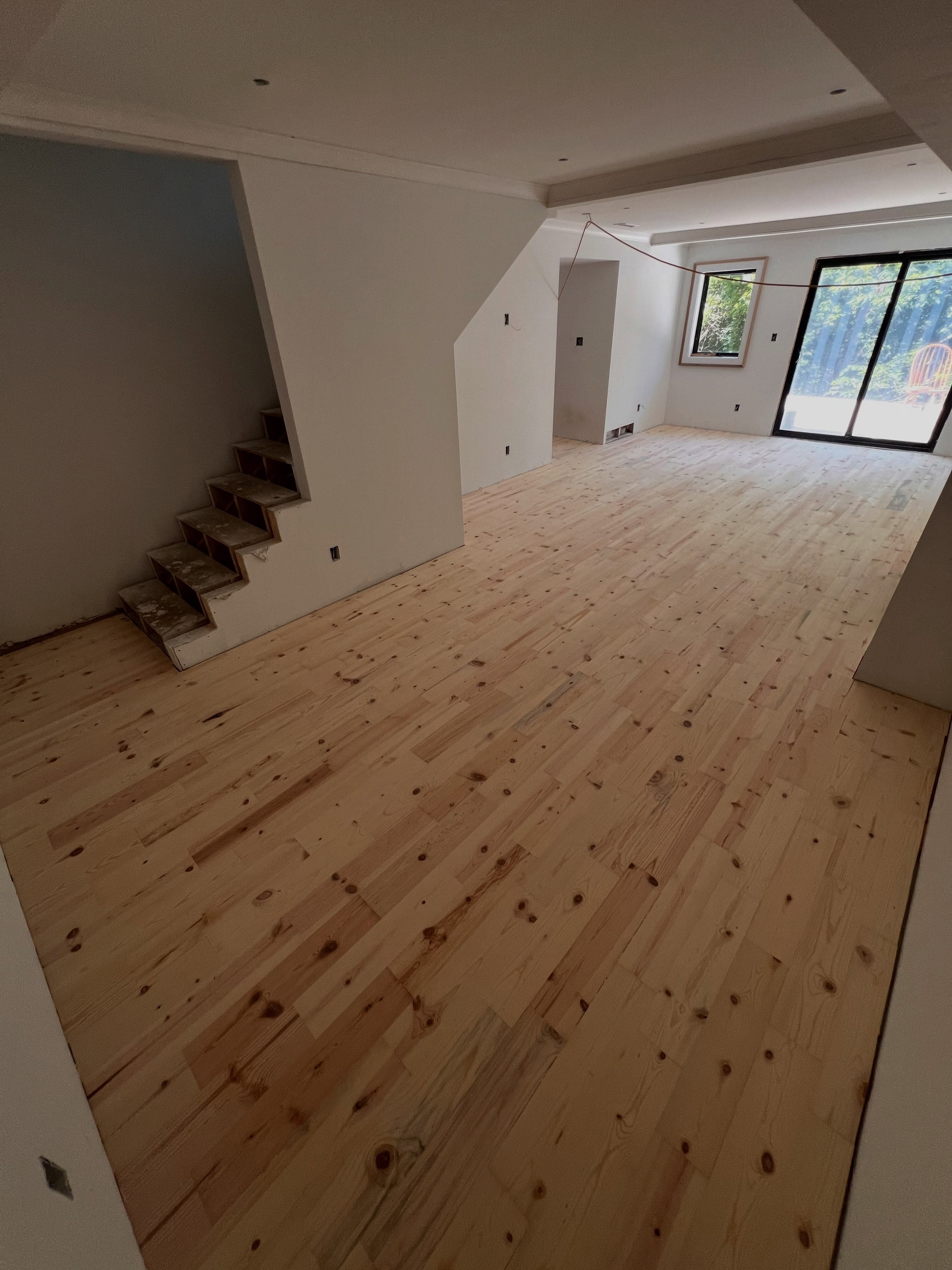 Large open residential space with natural pine subfloor