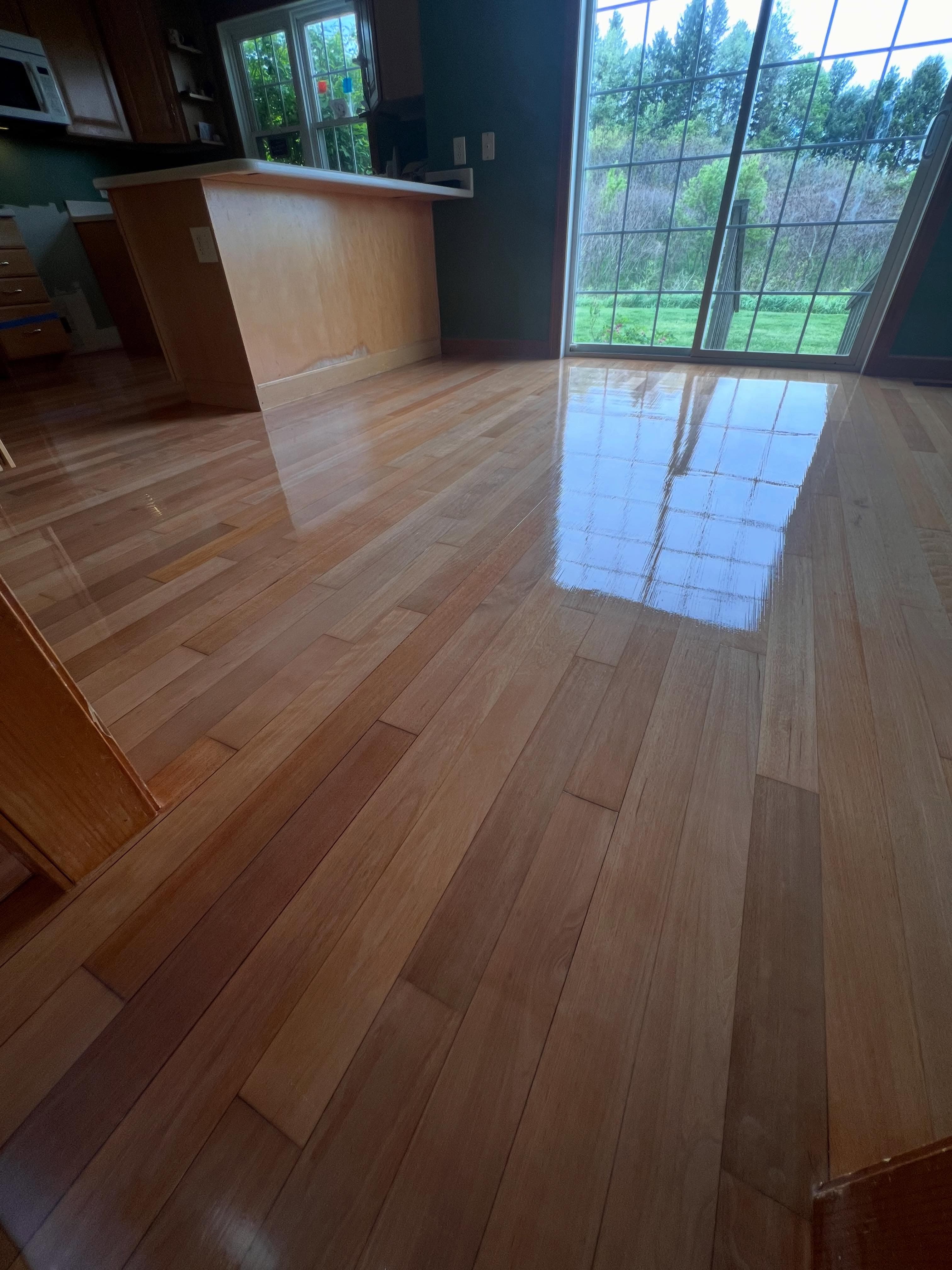 Expansive room with polished hardwood plank flooring reflecting natural light