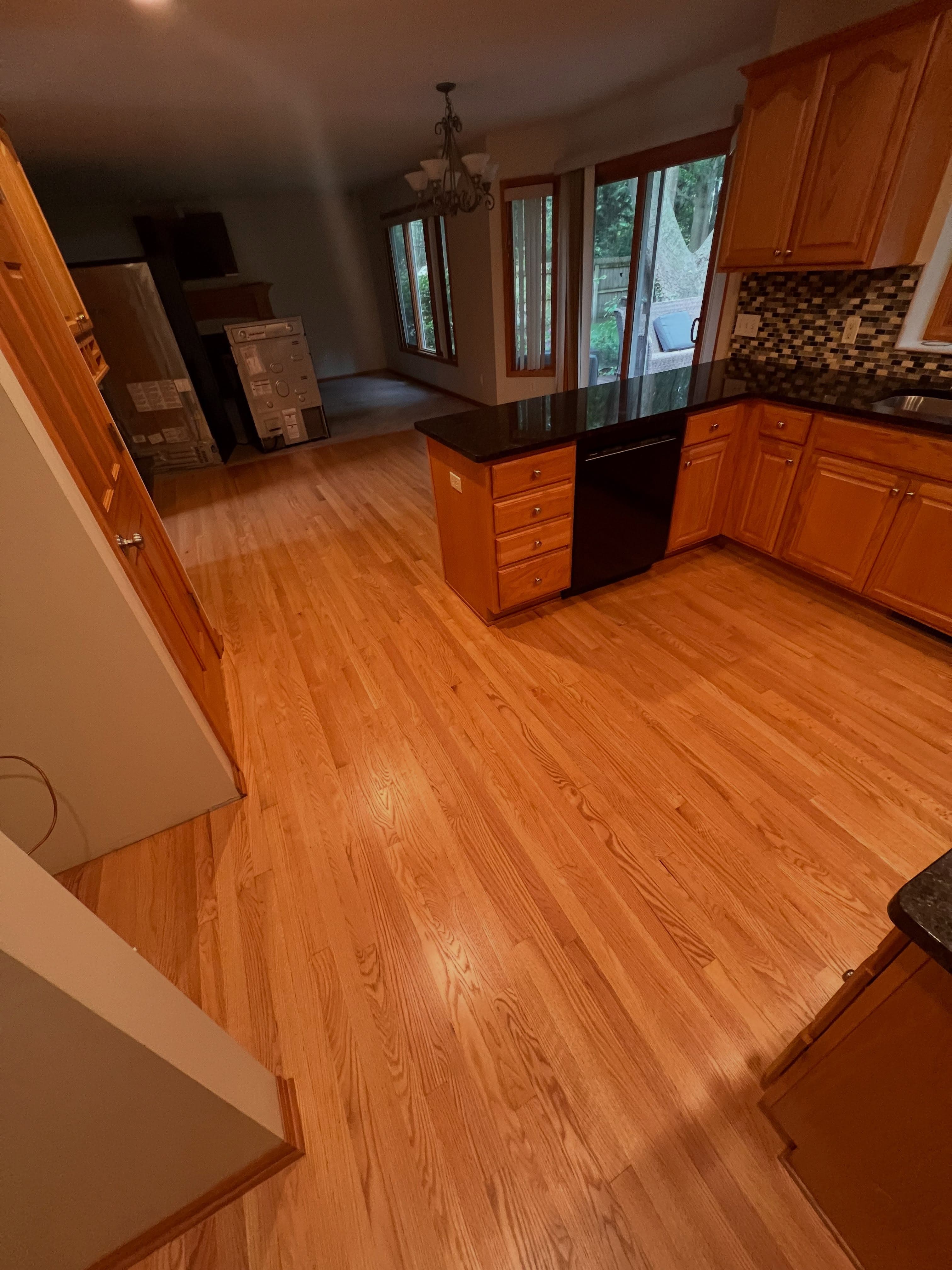 Spacious kitchen and living area with gleaming honey-amber hardwood flooring